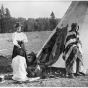 Black and white photograph of Frances Densmore outside of tipi with American Indians, 1900. 