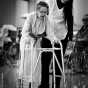 Therapist assists elderly stroke victim with a walker, Abbott-Northwestern Hospital, Sister Kenny Pavilion. 