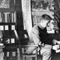 Black and white photograph of Alfred Carlsted counting sprouted kernels to determine the percent that germinated, 1914.