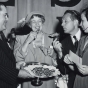 Black and white photograph of Philip Pillsbury, Eleanor Roosevelt, and Art Linkletter sampling Theodora Smafield’s winning recipe, 1949.