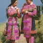 Color scan of a Hmong New Year postcard showing two young women in traditional Hmong dress, c.1980s.