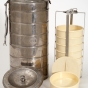 Color image of an insulated canister used to keep food warm in airline meal service. The canister, which contains eight plastic bowls, was used by Northwest Airlines, c.1950s.