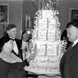 Black and white photograph of congregants lighting candles on a cake at the fiftieth anniversary celebration for Kenesseth Israel Synagogue in Minneapolis, c.1935.