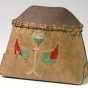 Miniature birchbark makak (Ojibwe storage basket) decorated in floral motifs employing colored cord and yarn. The makak is filled with maple sugar.