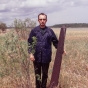 Color photograph of a Northwest angle marker and author William E. Lass provides a sense of the marker's scale, 1972.