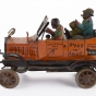 Metal windup toy car model of the Fresh Air Taxicab from the radio show Amos 'n Andy, made by Louis Marx and Co. of New York. It features two caricatured men riding in the car, the driver is wearing an orange vest, while the passenger wears a blue jacket and smokes a cigar. Made sometime between 1930 and 1939.