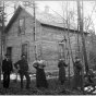 People posed in front of a house built for Hinckley fire victims, after September 1, 1894.