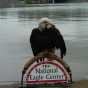 Color image of Angel, a female bald eagle and one of the National Eagle Center's first ambassadors, perches on top of the center's sign.