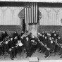 Black and white photograph of Director Arthur Wasshausen leading the Citizens Band in Crookston's opera house in 1907.