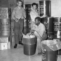 Black and white photograph of people stocking fallout shelter at St. Casimir’s School, St. Paul, 1962.