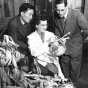 Black and white photograph of Entomology professor Henry C. Chiang (left) inspecting corn stalks for signs of corn borers with F. G. Holdaway and Jeanne Marie Hellberg, 1951.