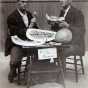 Black and white photograph of W. L. Carlyle and R. S. Mackintosh eating watermelon that was awarded first premium probably at the Minnesota State Fair, 1895. 