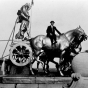 Black and white photograph of men posed at the quadriga, c.1913. Photographed by Earl Conrad.