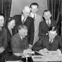 Black and white photograph of Governor Elmer Benson signing a barbers’ fair trade bill. Photograph by the St. Paul Daily News, 1937. 