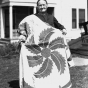 Black and white photograph of woman with prize-winning quilt, 1926. 