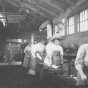 Black and white photograph of an Agriculture Extension, short course in Blacksmithing; women at the forges, 1908.