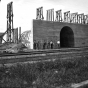 Black and white photograph of Northern Pacific Railway engineers in front of completed concrete archway. View to southwest, fall 1906.