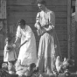 Women and child feeding chickens