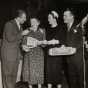 Black and white photograph from the Grand National Bake-Off at the Waldorf Astoria, New York, 1950. Left to right: Art Linkletter, contestant, Duchess of Windsor (the former Wallis Simpson), Philip Pillsbury.