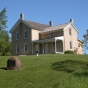 Image depicting the 1876 Chaska brick Wendelin and Julianna Grimm house, showing 1924 Grimm alfalfa marker in foreground, 2004.