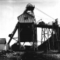 Black and white photograph of an iron ore shaft and stock pile in Virginia, Minnesota, 1915. 