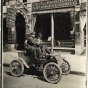 Black and white photograph of Michael Dowling and a passenger in a car in front of the E.H. Erickson Artificial Limb Company, c.1905.
