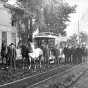 Black and white photograph of a horse-drawn streetcar in Minneapolis; sign reads Sixth Street, Monroe Street and Eighth Avenue, c.1885. This photograph shows a second team of horses ready to relieve the team on the horsecar.