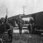Black and white photopgrah of people loading horse and possessions of homesteaders into Great Northern Railway boxcar, date unknown.