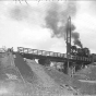 Black and white photograph of a construction crew at work on a bridge along the right of way, 1929. Photograph by Briol Studio.