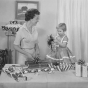 A mother and her daughter wrap gifts with Sasheen ribbon in this ca. 1955 advertisement for 3M.