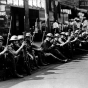 Black and white photograph of the National Guard seated along street curb, Minneapolis, 1934.