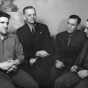 Black and white photograph of Jake Cooper, Oscar Coover, Harry DeBoer, and Max Geldman at the Minneapolis Headquarters during the time of their trial, 1941.