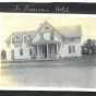 Photograph of the front of the Riverside Hotel, sometimes called the St. Francis Hotel. Four people stand or sit on the porch. Anoka County Historical Society, Object ID# JE0038-2. Used with the permission of Anoka County Historical Society.