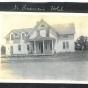 Photograph of the front of the Riverside Hotel, sometimes called the St. Francis Hotel. Four people stand or sit on the porch. Anoka County Historical Society, Object ID# JE0038-2. Used with the permission of Anoka County Historical Society.