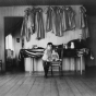 Black and white photograph of a young child inside a Native American boarding school, c.1890s.