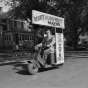 Black and white photograph of a “Hubert Humphrey for mayor” campaign worker rides his Cushman scooter before the Minneapolis mayoral election, 1947. 