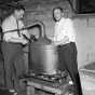 Black and white photograph of two men breaking apart an illegal still,1940. Photographed by the Minneapolis Star Tribune.