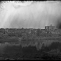 Black and white photograph of St. Anthony looking across Nicollet Island at Winslow House, right, and Universalist Church, left, ca. 1860. 