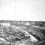 Black and white photograph of Swede Hollow with the Sixth Street Bridge in the background, c.1900.