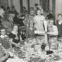 Black and white photograph of Crookston BPW club members at a table representing Denmark during an international breakfast event, 1958.