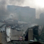 First responders next to the smoking wreckage of the bridge. Photo taken by Wikimedia Commons user Tony Webster, August 1, 2007. CC-BY-2.0