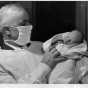 Dr. Russell Heim with a baby left at his office (12 West Lake St., Minneapolis), 1947. Photograph by Paul Siegel. Published in the Minneapolis Morning Tribune, October 31, 1941.