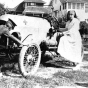 Black and white photograph of a Red Cross nurse, and likely Motor Corps officer, 1918. The car has the Red Cross symbol on the hood and was likely part of the Minnesota Motor Corps. 