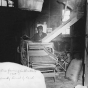 Black and white photograph of a man operating electric fanning mill, W. A. Benitt farm, Dakota County, 1939.