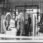 Black and white photograph of Assistant keeper Tom Hassing standing next to diesel air compressors at Split Rock Lighthouse c.1945.