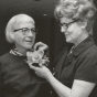 Black and white photograph of St. Catherine’s alumna Betty Hubbard (right) pinning a corsage on Alice Gustava Smith (Sister Maris Stella, left) at the College of St. Catherine in 1971. Photographed by P.J. Strasser. 