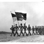 Soldiers marching with Twin Cities Ordnance Plant flag