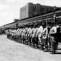 Black and white photograph of guardsmen arriving by train for annual field training at Camp Ripley in 1938.  