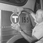 A transit worker applies a “T” (for transit) decal to one of the old Twin City Lines buses before being sent out on the streets under new management for the first time in September 1970. All of the former TCL buses were eventually repainted a solid red before until they were replaced. Photo by the St. Paul Pioneer Press; used with permission.