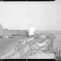 Looking east from the Robert Street bridge at a Milwaukee Road freight train behind double-headed steam locomotives passing the St. Paul Union Depot.